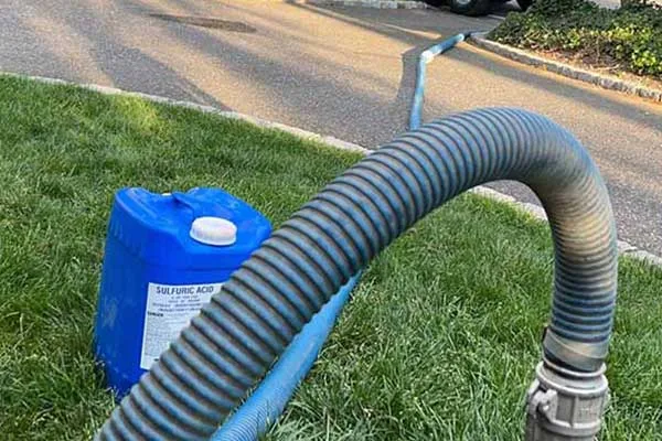 A hose with a blue bucket next to it near a septic installation site.