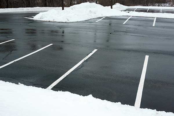 A parking lot with snow removal in progress.